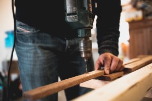 Person drilling through wood.